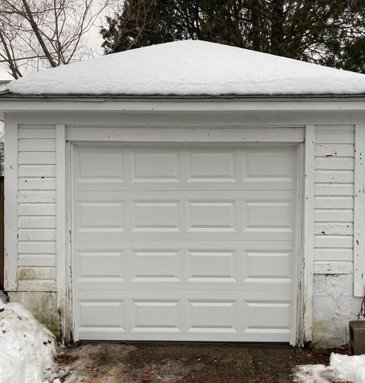 Double car classic insulated steel raised panel garage door framed with a white trim